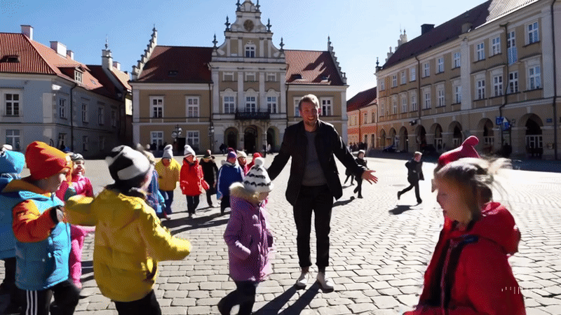 Osoba dorosła opiekująca się grupą dzieci – symbol pracy wychowawcy w placówce opiekuńczo-wychowawczej.